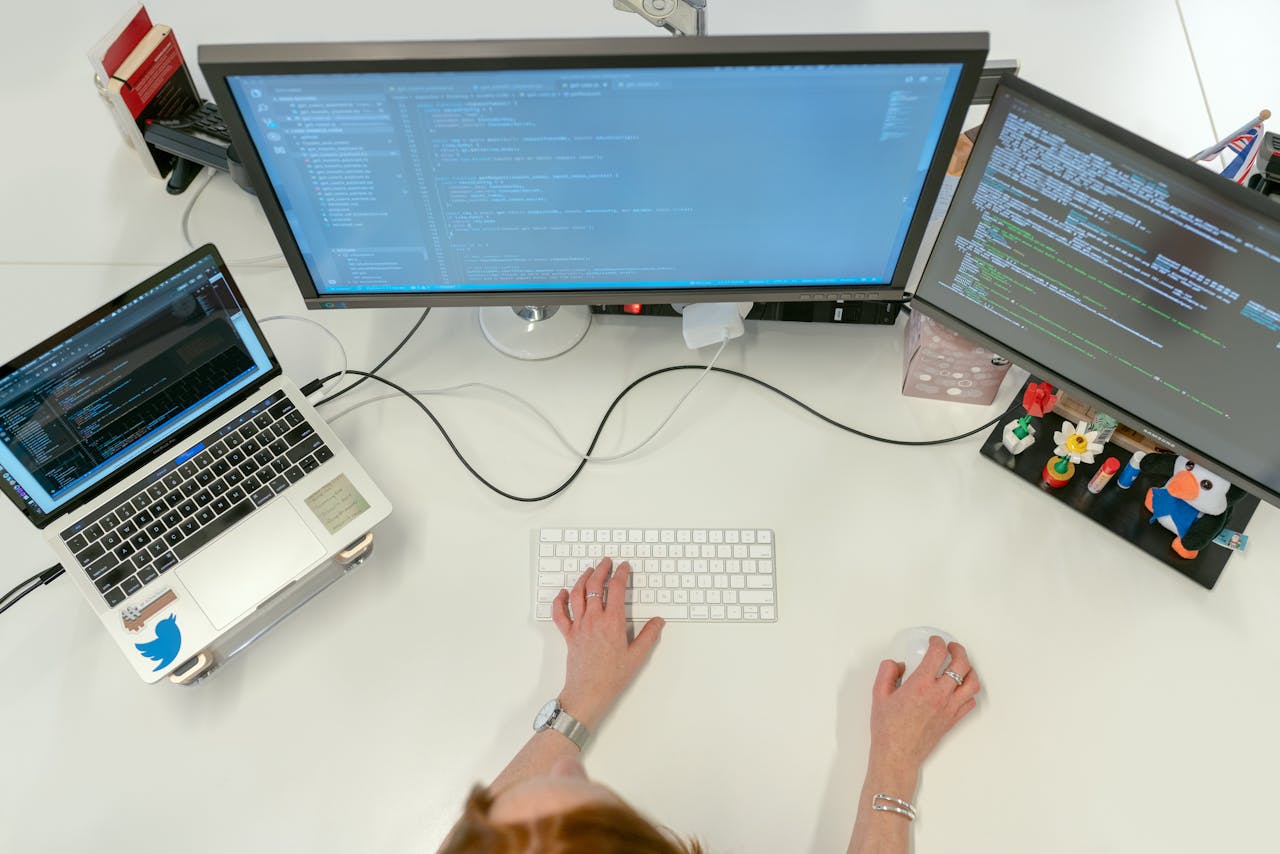 Crafting Captivating Headlines: Your awesome post title goes here A female software engineer coding on dual monitors and a laptop in an office setting.